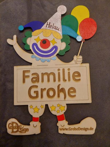 Bunter Clown mit individueller Aufschrift Bunter Clown mit Luftballons, hält ein Schild mit "Familie Grohe".