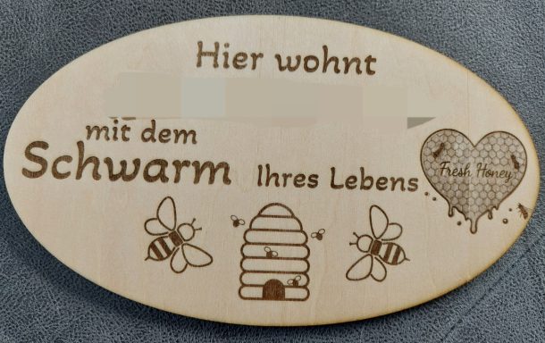 Holzkochlöffel mit individueller Gravur und Bild Holzschild mit der Aufschrift "Hier wohnt mit dem Schwarm ihres Lebens" und Bienenmotiven.