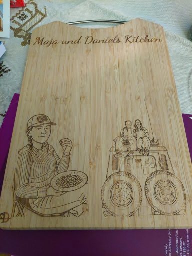 Holzbrett / Schneidebrett mit personalisierter Gravur und Motiv Schneidebrett aus Holz mit graviertem Design von Koch und Küchengeräten.